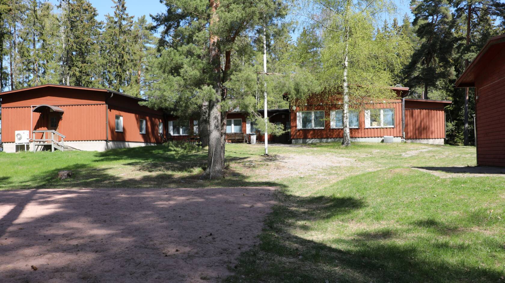 Haukharjan puuverhoiltu leirikeskusrakennus rannasta päin katsottuna.