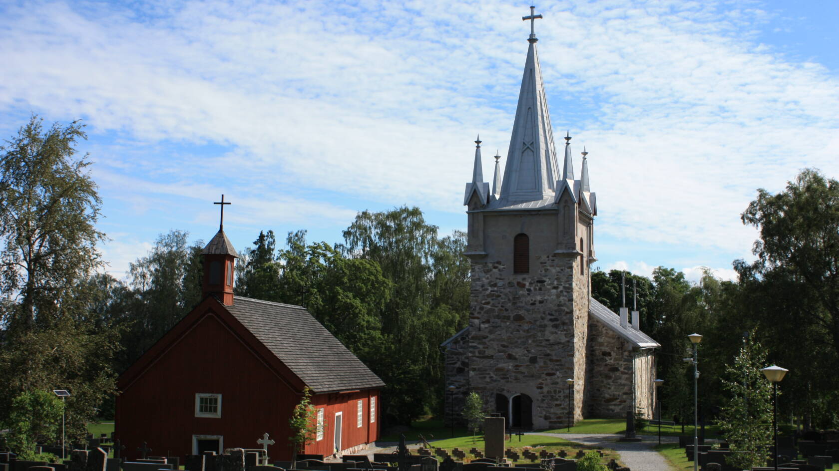 Pyhämaan kivikirkko tornipäästä, edessä punainen uhrikirkko ja hautausmaa.