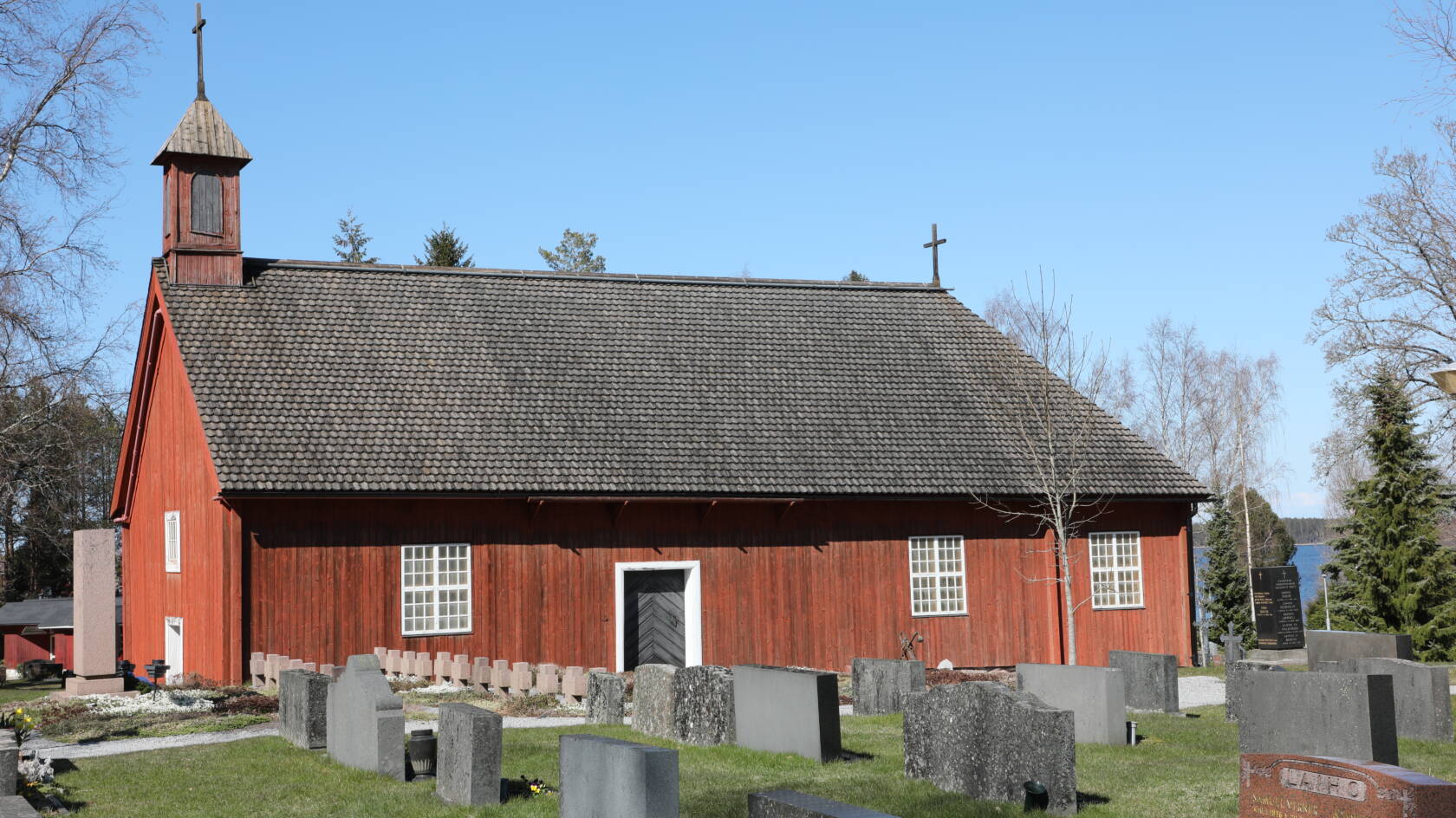 Pyhämaan punainen uhrikirkko ulkoa päin katsottuna. Taustalla näkyy meri.