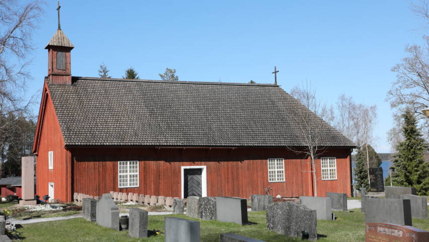 Pyhämaan punainen uhrikirkko ulkoa päin katsottuna. Taustalla näkyy meri.