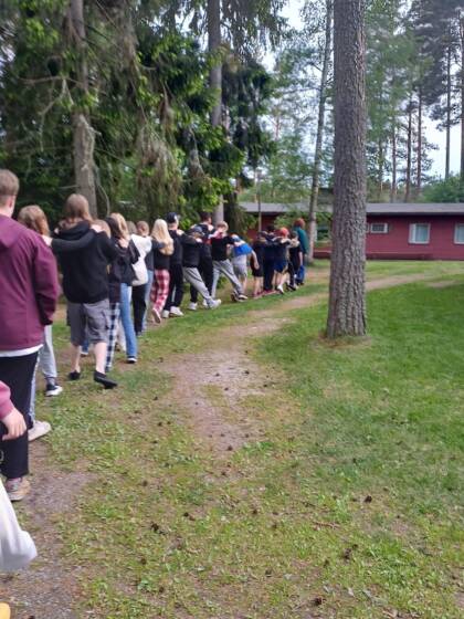 Nuoria kävelemässä jonossa lipunnostoon