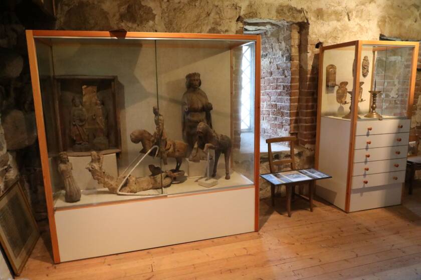 Museovitriineitä Kalannin kirkon yläkerrassa. Kaapeissa vanhoja kirkon säilyneitä esineitä.