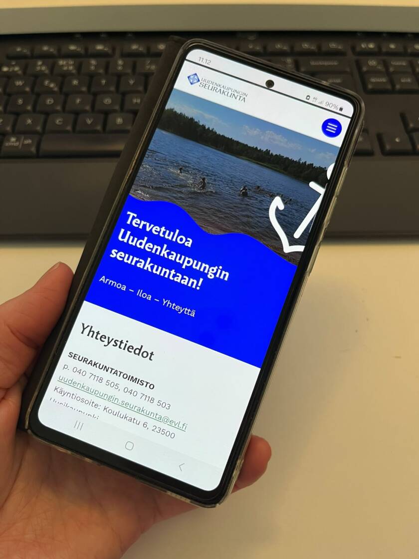 Kännykkä, näytöllä seurakunnan etusivu