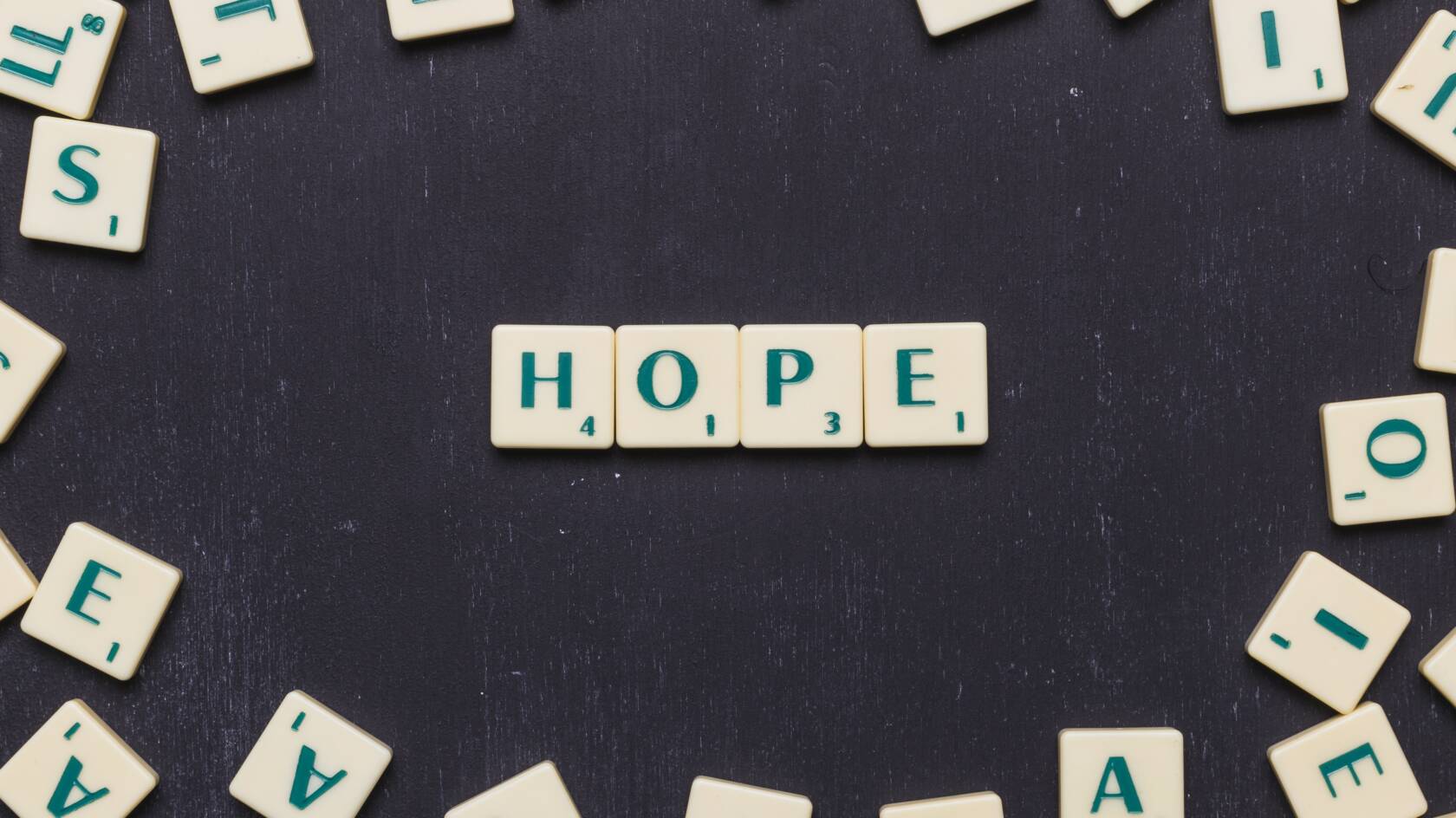 Scrabble-pelin kirjainlaattoja, joista muodostuu sana HOPE.