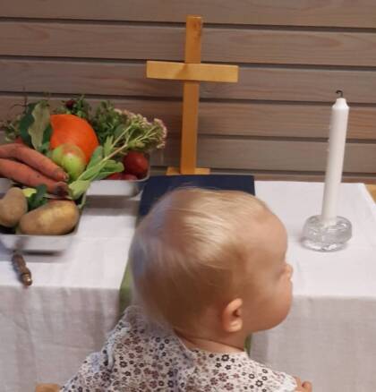 lapsi pienen alttarin edessä polvillaan